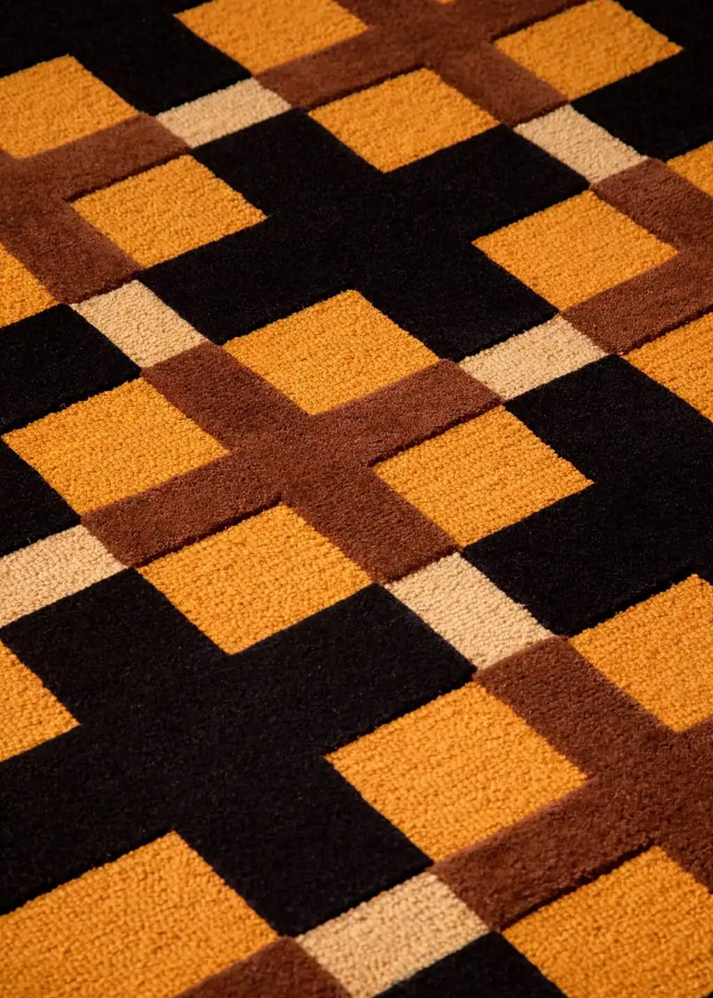 Geometric patterned rug with brown, orange, and beige squares on a black background