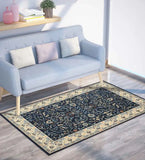 Navy blue traditional handwoven rug with floral patterns under light blue sofa in modern living room