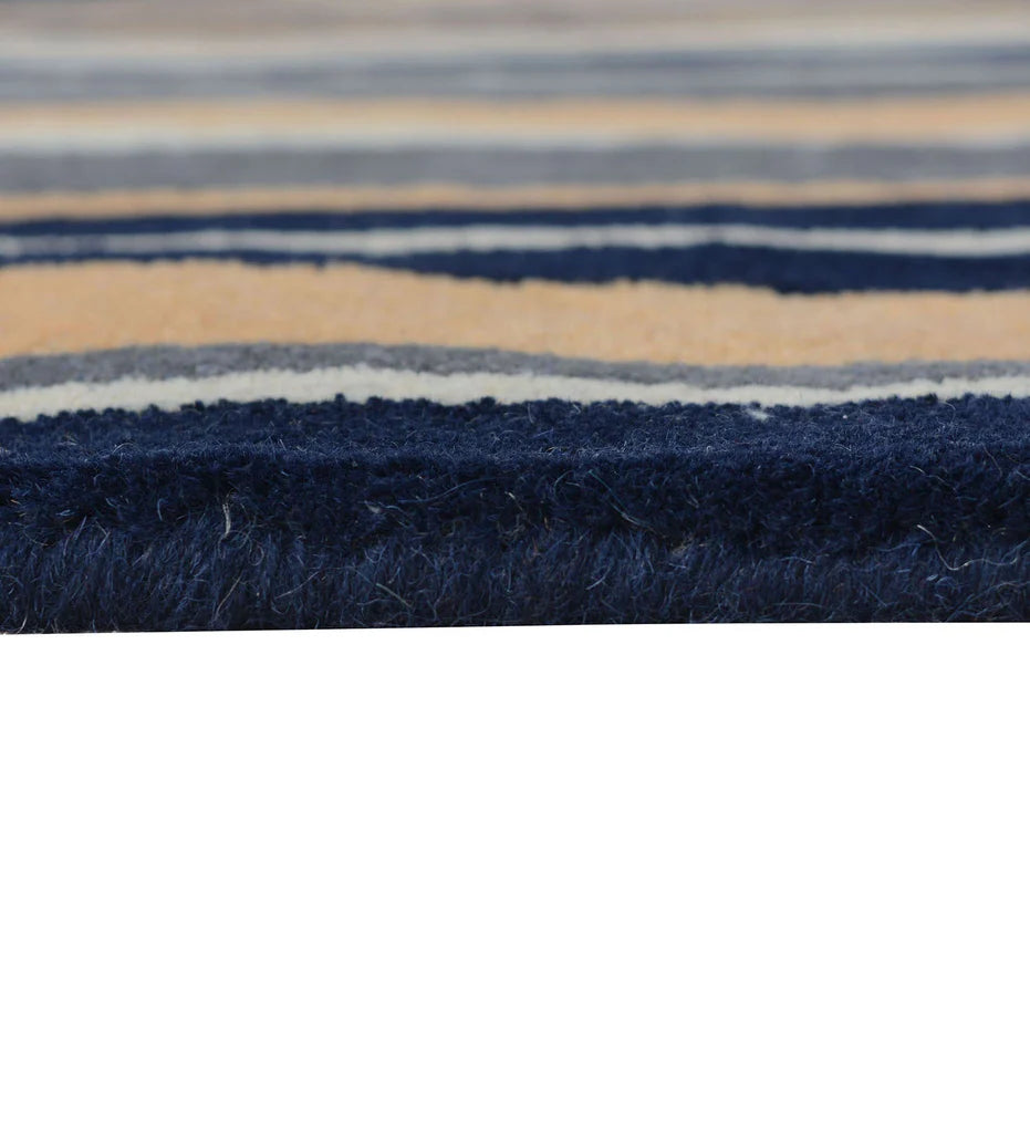 Soft wool hand-tufted rug with vertical pattern in navy, gray and peach hues.