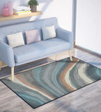 Modern living room with light blue sofa and abstract earth tone wave patterned rug on wooden floor