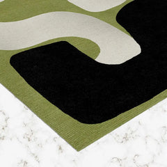 Contemporary abstract area rug with black, white, and green tones.