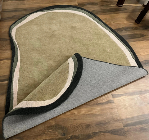 Irregular hand-tufted rug with olive, beige, and charcoal colors.