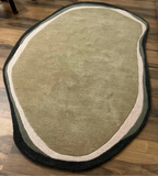 Luxury hand-tufted wool rug in irregular oval shape.
