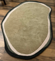 Luxury hand-tufted wool rug in irregular oval shape.