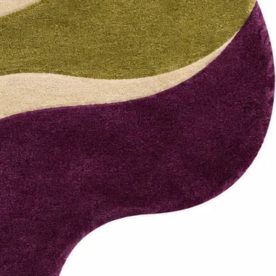 An abstract, wavy-edged area rug with a modern organic pattern in olive green, dusty pink, cream, and deep plum purple, shown from a top-down view on a white background.