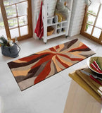 Handwoven abstract orange and brown wool rug in bright kitchen with wooden doors and white brick walls