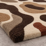 Close-up of brown and tan organic shapes on cream wool rug for a bedroom, 6x9 size