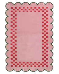 Pink checkerboard rug with scalloped green-edged border and red square pattern