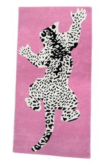 Hand-tufted pink rug with black and white leopard design.