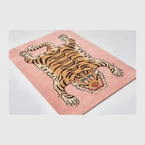 Pink rug with a modern tiger motif featuring brown and black stripes, handwoven luxury home decor