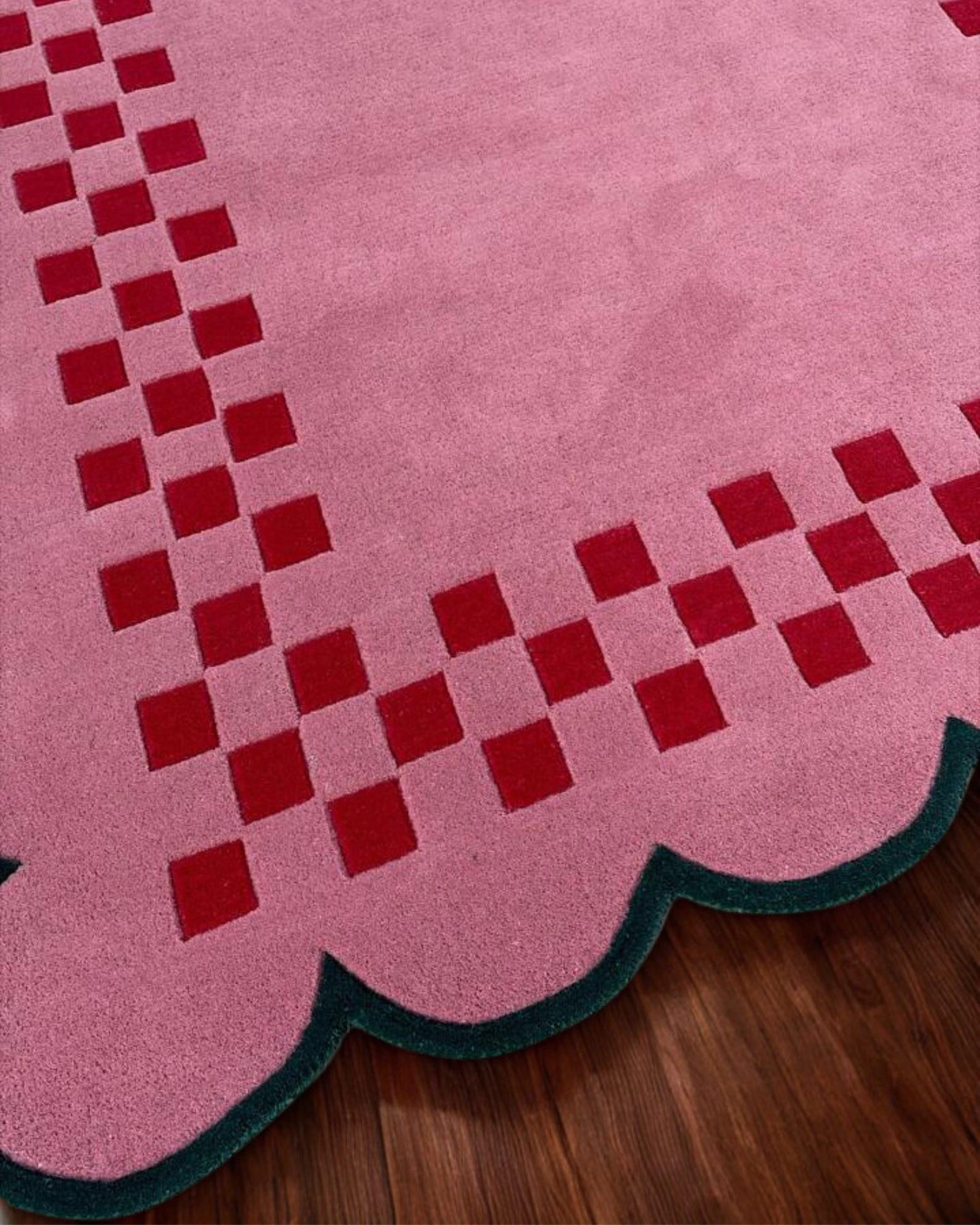 Cute pink area rug featuring scalloped trim and checkerboard design for modern home decor