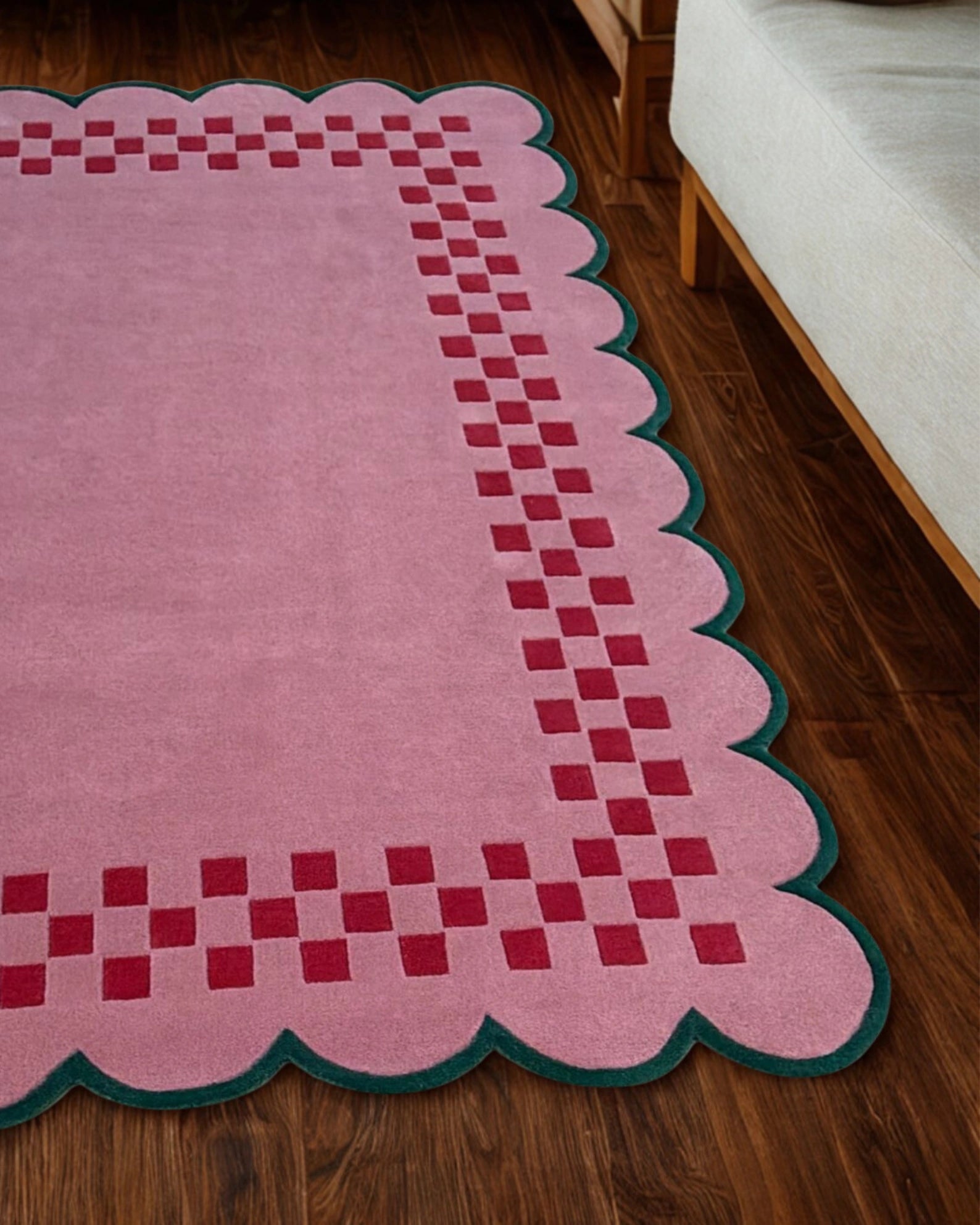 Pink checkerboard rug with scallop edges placed in a cozy bedroom setting