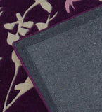 Close-up of purple floral vine rug with beige flower patterns and gray woven backing
