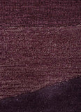 Close-up of purple textured handwoven rug with modern plum wave pattern