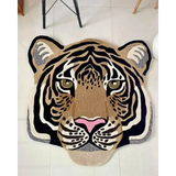 Hand-tufted wool rug shaped like a realistic tiger face with black, beige, white, and pink accents on tiled floor