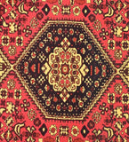 Close-up of a handwoven luxury red antique rug with intricate black and cream geometric patterns