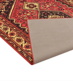 Red antique-style luxury handwoven rug with intricate floral patterns and a folded corner showing the backing