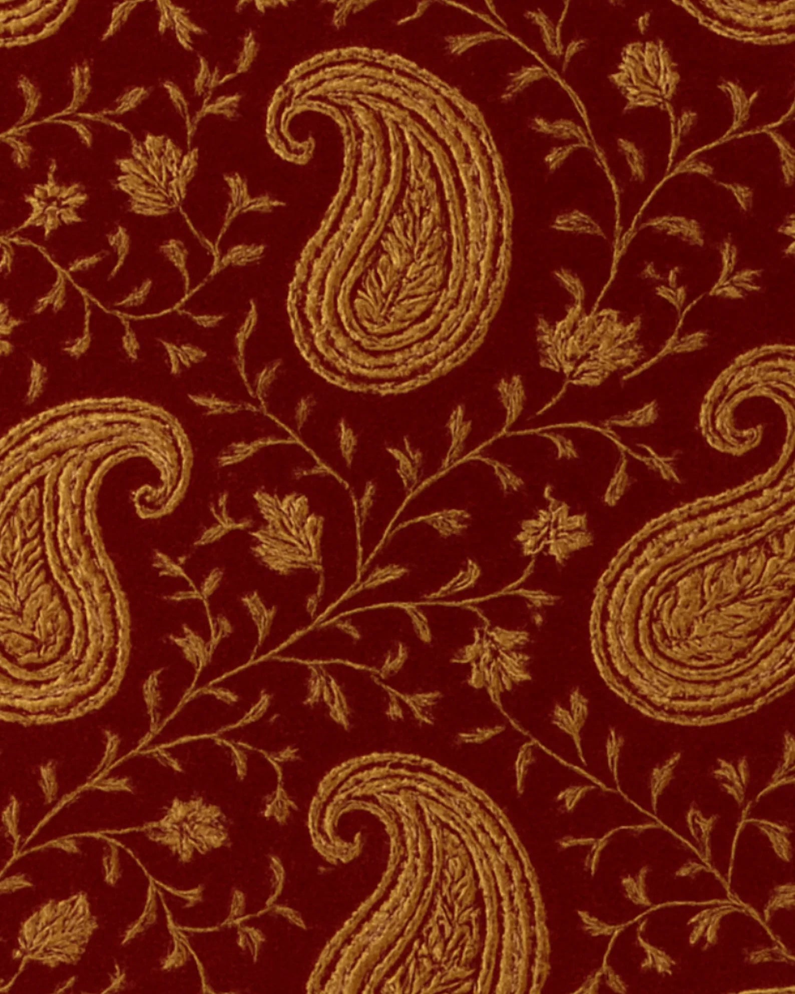 Traditional paisley patterned wool rug in rich red and gold tones.