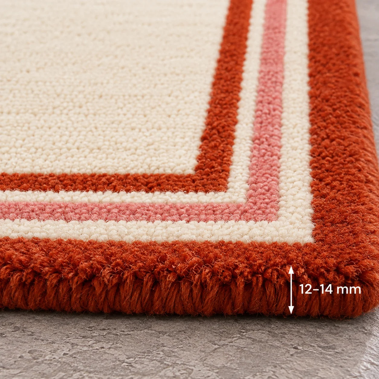 Close-up of layered red and ivory geometric border on wool rug 9x12