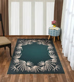 Rich teal rectangular rug with beige palm leaf border on wooden floor in bright living room