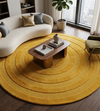 Round yellow rug in a living room with a coffee table and sofa.
