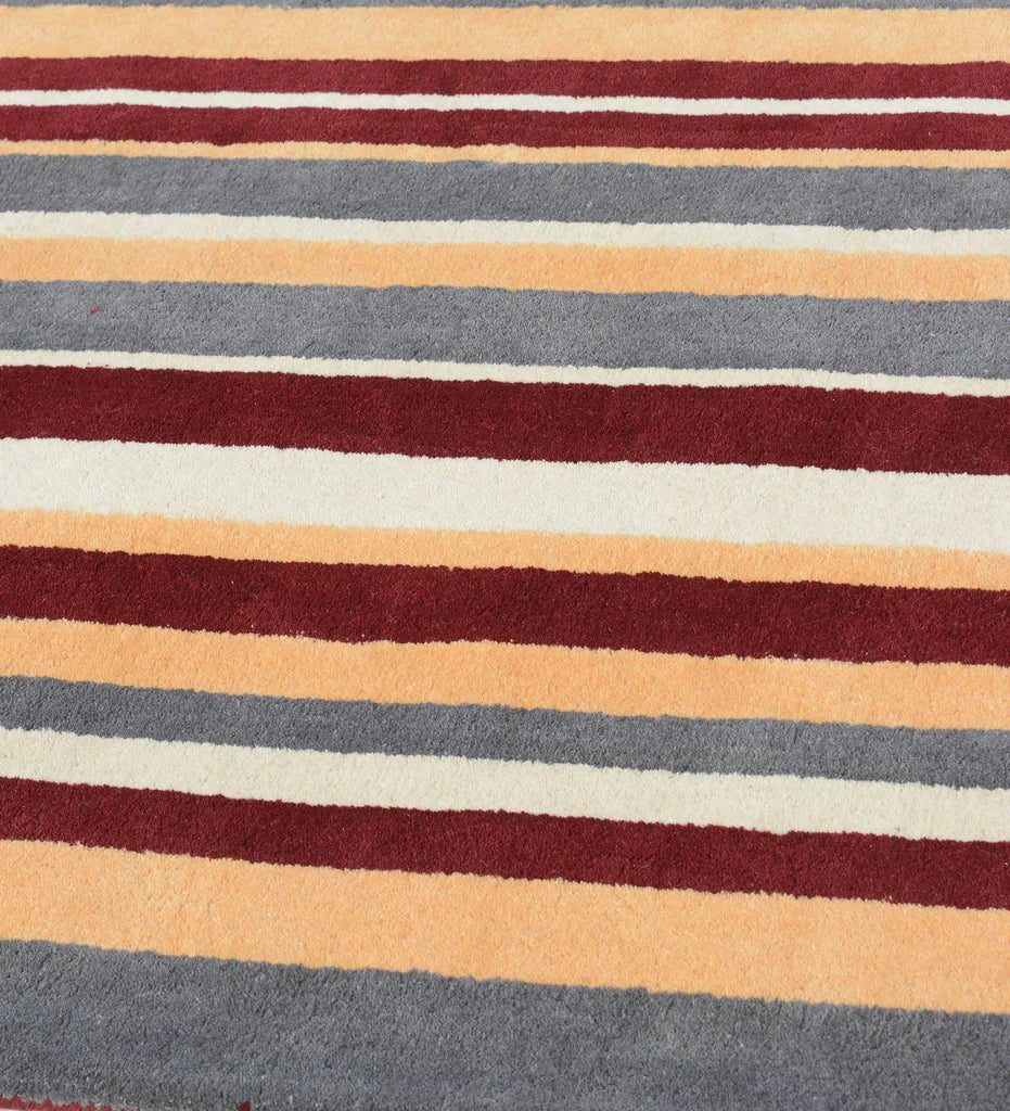 Modern hand-tufted rug in earthy rust red and mustard yellow hues.