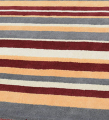 Modern hand-tufted rug in earthy rust red and mustard yellow hues.