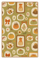 Harvest rug with pumpkins, bows, and leaves on green background.