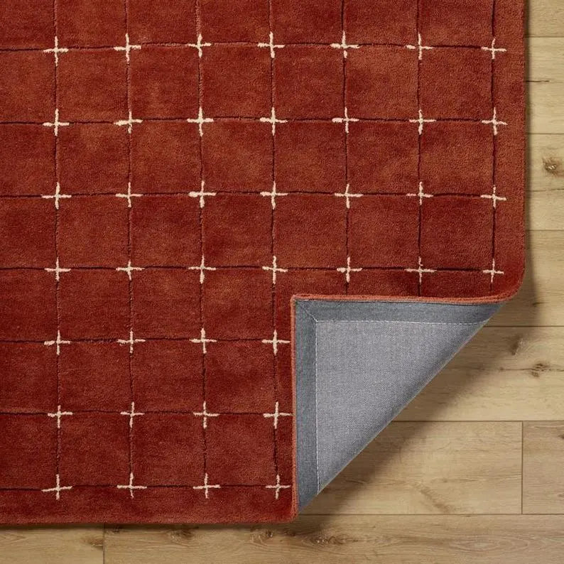 Modern wool rug with cross-stitch grid pattern for dining area.