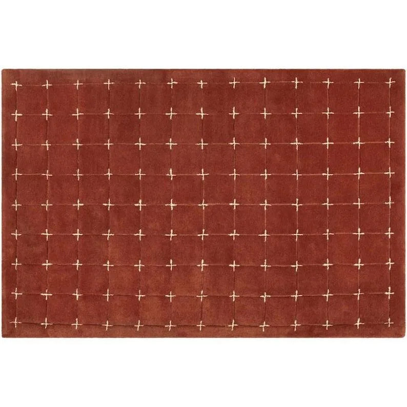 Modern geometric accent rug in red and white cross-stitch design.
