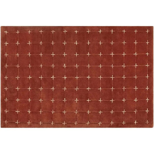 Modern geometric accent rug in red and white cross-stitch design.