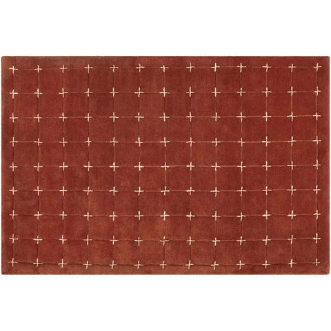Modern geometric accent rug in red and white cross-stitch design.