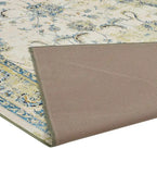 Shabby chic luxury area rug with blue floral patterns and beige backing folded at corner