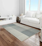 Modern living room with silver gray ombre striped rug on wooden floor beside white sofa and console