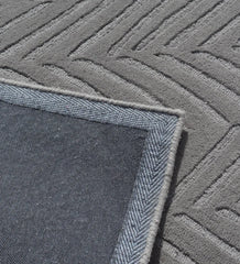 Minimalist grey hand-tufted rug with chevron linear motif