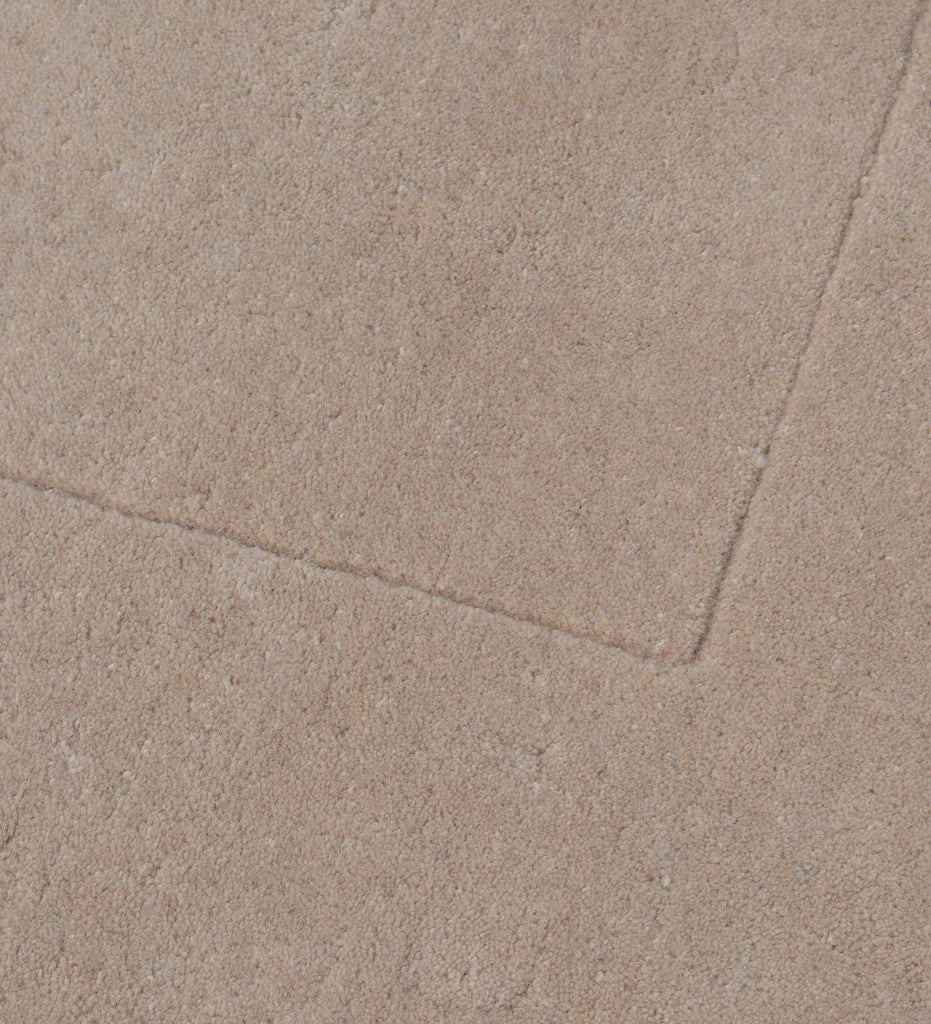Luxury solid hand-tufted wool rug with soft beige tone