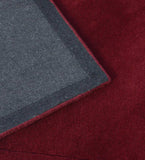 Minimalist maroon wool rug with embossed detailing