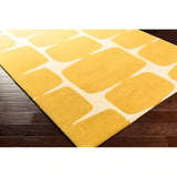 Handwoven Sunbeam Meadow rug featuring yellow geometric shapes on dark hardwood floor
