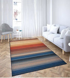 Modern living room with Sunset Horizon Stripe rug featuring warm red, orange, and blue horizontal stripes on wooden floor