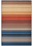 Handwoven striped rug with sunset-inspired warm reds, oranges, browns, beige, and blue tones, luxury home décor