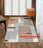 Taupe modern geometric rug with striped rectangular patterns on hardwood floor in stylish room