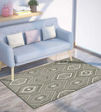 Taupe and ivory hexagon boho design rug on wood floor with light blue sofa and decorative cushions