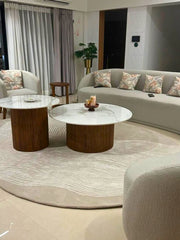 Luxury oval wool rug in beige tones with subtle white linear patterns.