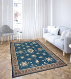 Teal blue handwoven rustic rug with intricate patterns on herringbone wood floor in bright modern living room