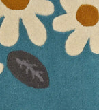 Luxury wool rug with daisy and vine design in teal and white