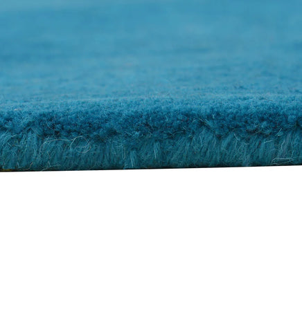 Minimalist teal wool rug with clean border pattern