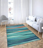 Modern teal and coral abstract area rug in bright living room with gray sofa and patterned chair