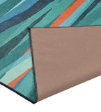 Handwoven luxury rug with teal, coral, and blue abstract stripe design, showing backside with stitched edges