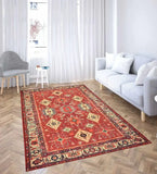 Terracotta red traditional handwoven rug with intricate patterns in modern living room with gray sofa and striped chair