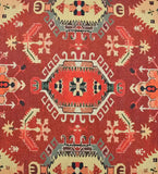 Terracotta red traditional handwoven rug with geometric and floral motifs in beige, green, and black